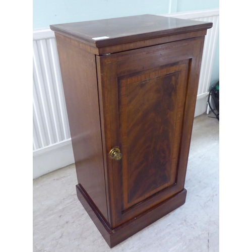 93 - A late Victorian crossbanded and string inlaid mahogany pot cupboard, enclosed by a full-height pane... 