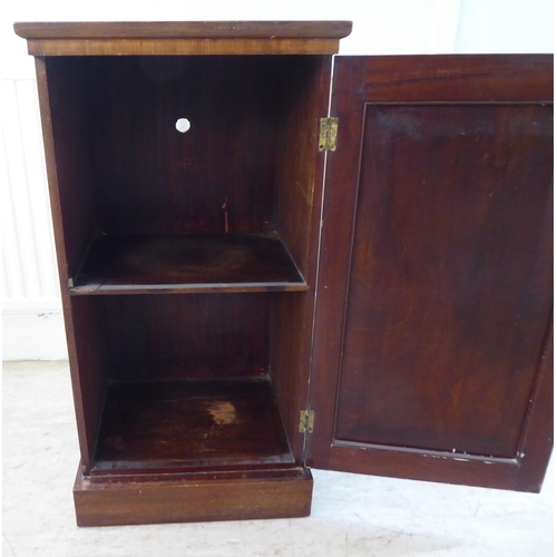 93 - A late Victorian crossbanded and string inlaid mahogany pot cupboard, enclosed by a full-height pane... 