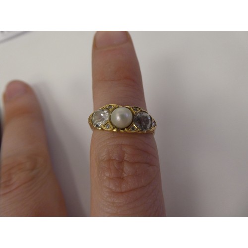 100 - A gold coloured metal ring with a scrolled shank, rubover set with two diamonds and a single pearl  ... 