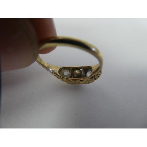 100 - A gold coloured metal ring with a scrolled shank, rubover set with two diamonds and a single pearl  ... 