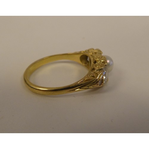 100 - A gold coloured metal ring with a scrolled shank, rubover set with two diamonds and a single pearl  ... 