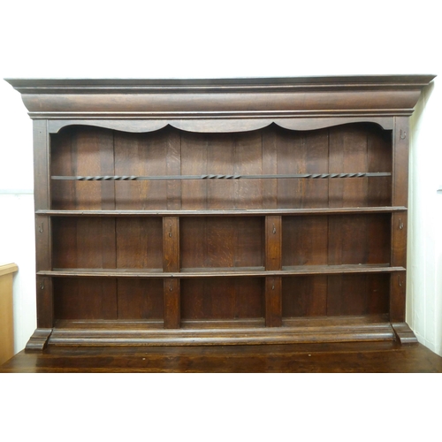 119 - A late 18th/early 19thC stained oak dresser, the superstructure with three open plate racks, the bas... 