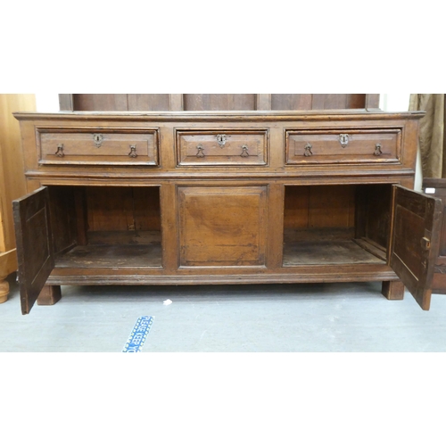 119 - A late 18th/early 19thC stained oak dresser, the superstructure with three open plate racks, the bas... 