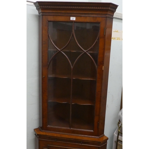 20 - A modern yewwood corner cabinet with a glazed, panelled door, raised on bracket feet  75