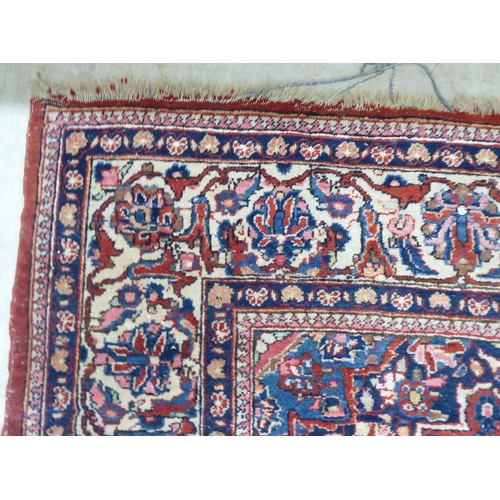 227 - A Persian rug, profusely decorated with floral designs, on a mainly red ground  53