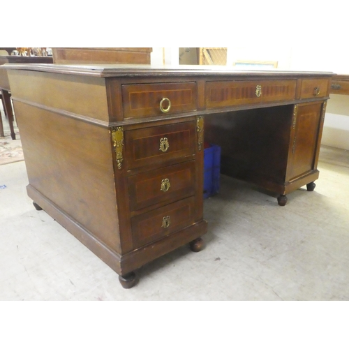 239 - An early 20thC string inlaid mahogany, twin pedestal partner's desk with an arrangement of drawers a... 