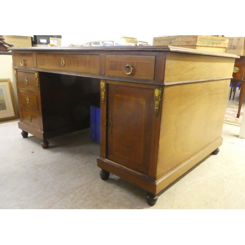 239 - An early 20thC string inlaid mahogany, twin pedestal partner's desk with an arrangement of drawers a... 