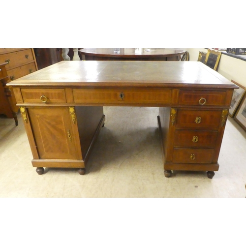 239 - An early 20thC string inlaid mahogany, twin pedestal partner's desk with an arrangement of drawers a... 