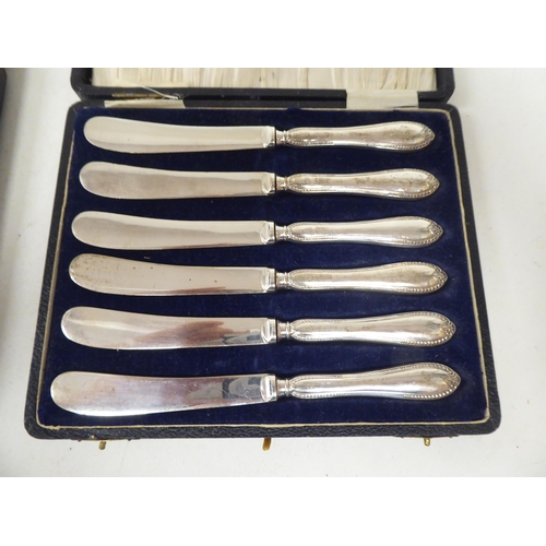 261 - Two sets of six loaded silver handled butter knives  both boxed; and one single  mixed mar... 