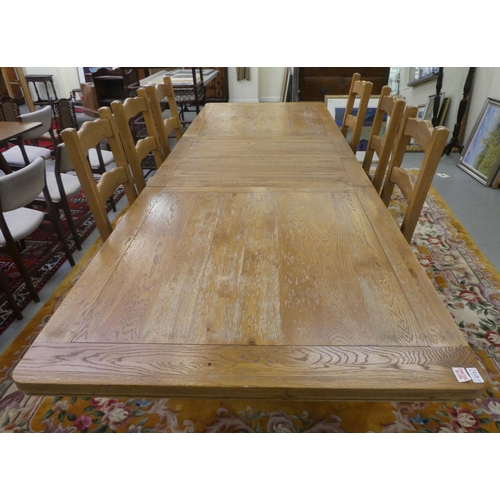 273 - A modern light oak dining table, the top with rounded corners, raised on turned pedestals and block ... 