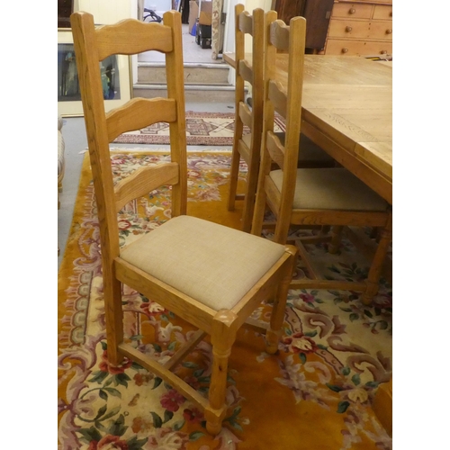 273 - A modern light oak dining table, the top with rounded corners, raised on turned pedestals and block ... 