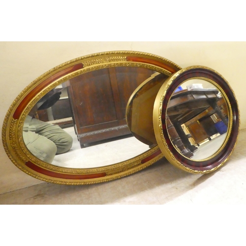 287 - Two modern mirrors, the oval plates in moulded gilt frames  18