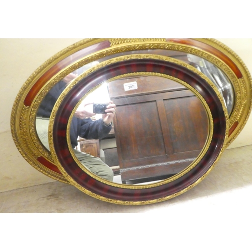 287 - Two modern mirrors, the oval plates in moulded gilt frames  18