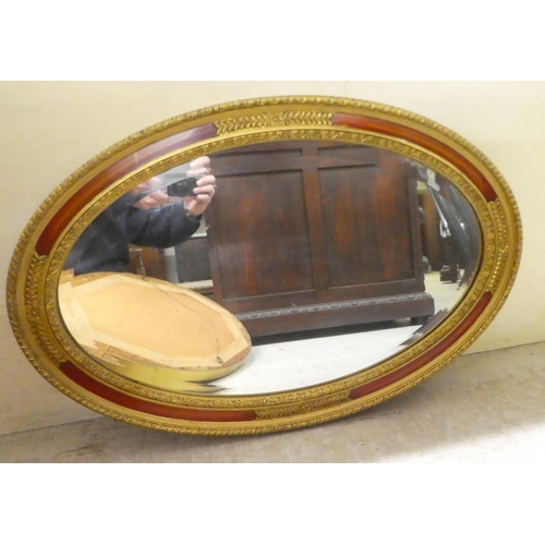 287 - Two modern mirrors, the oval plates in moulded gilt frames  18