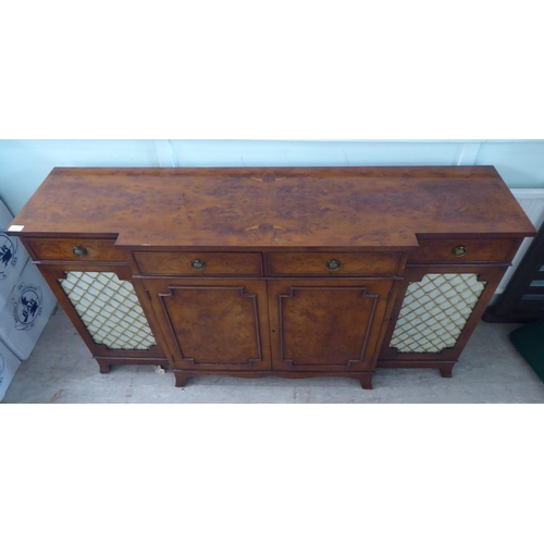 73 - A modern crossbanded walnut and walnut veneered breakfront sideboard with four frieze drawers, over ... 