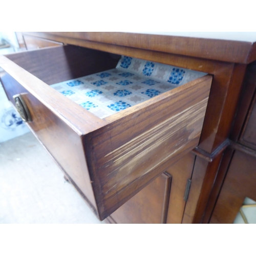 73 - A modern crossbanded walnut and walnut veneered breakfront sideboard with four frieze drawers, over ... 