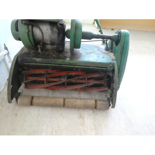 11 - A vintage petrol driven cylindrical lawn mower with a grass box