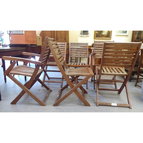 52 - A set of six modern stained teak framed folding terrace chairs with slatted backs and seats 