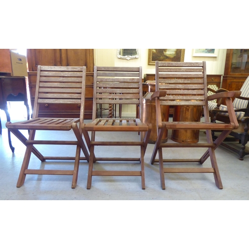 52 - A set of six modern stained teak framed folding terrace chairs with slatted backs and seats 