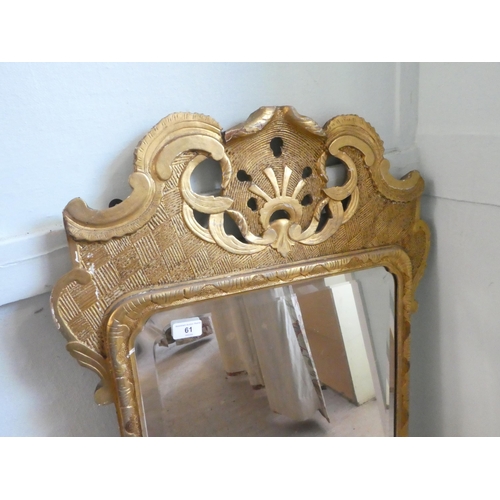 61 - An early 20thC mirror, the shaped, bevelled plate set in a gilded pine frame  44