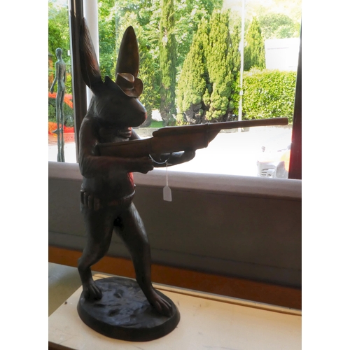 78 - A cast bronze model, a hunting hare holding a double barrel shotgun  36