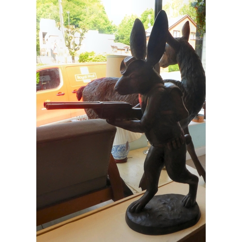 79 - A cast bronze model, a hunting hare holding a double barrel shotgun  36