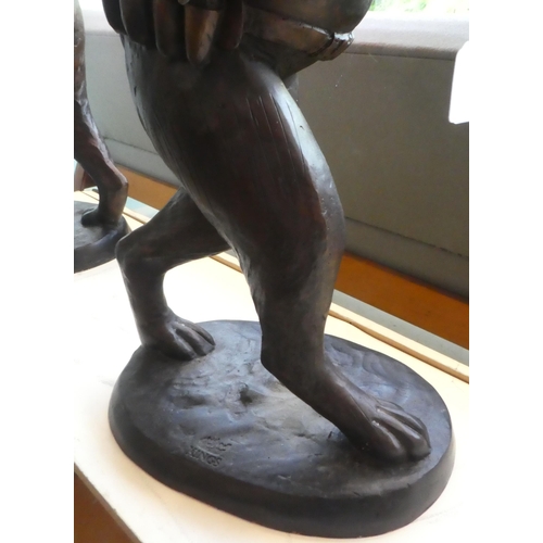 79 - A cast bronze model, a hunting hare holding a double barrel shotgun  36