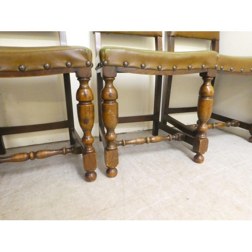 87 - A set of four 20thC Old English style oak and stained beech framed dining chairs with stud upholster... 