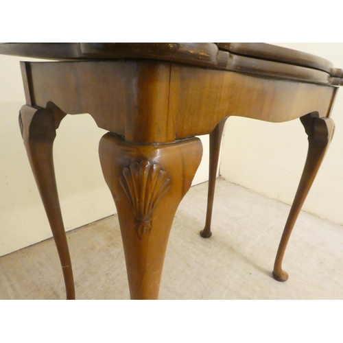 91 - A mid 20thC Queen Anne style quarter walnut veneered card table, the hinged top over slender legs an... 