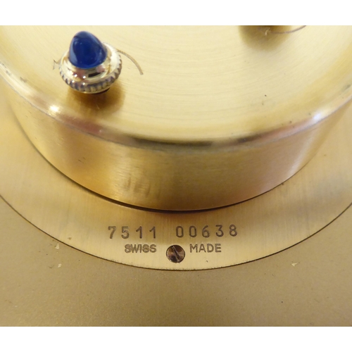 138 - A Cartier travel clock, No.7511 00638, in a gilded and black enamel oval case, on an easel stand; th... 