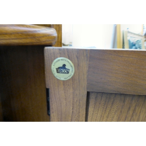 158 - An Ercol Golden Dawn beech and elm waterfall front, two tier bookcase, over a pair of panelled doors... 