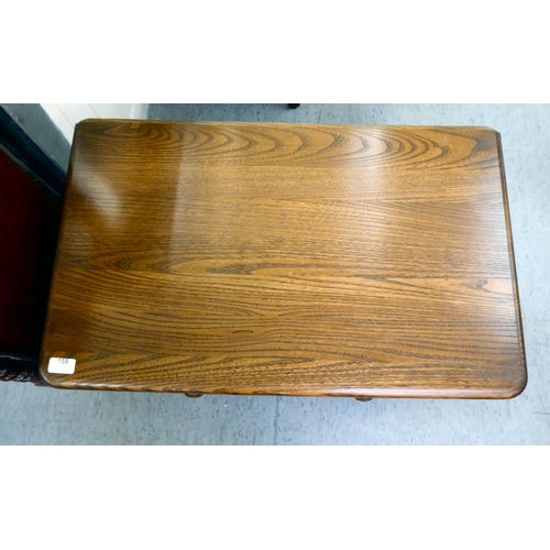 159 - An Ercol Golden Dawn beech and elm television stand, the top with a triangular fall flap, over an op... 