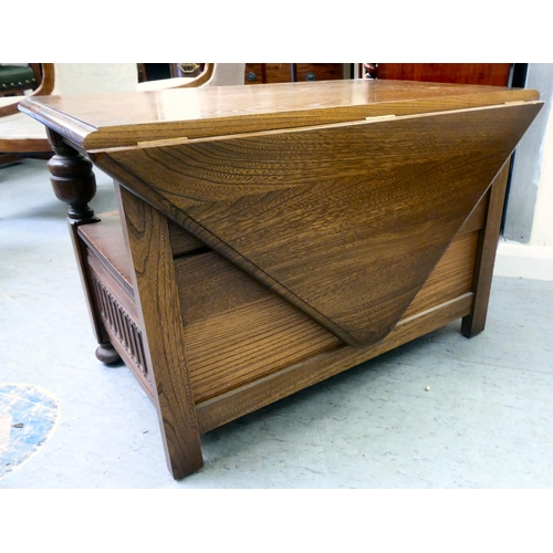 159 - An Ercol Golden Dawn beech and elm television stand, the top with a triangular fall flap, over an op... 