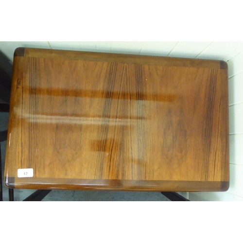 17 - A nesting set of three modern rosewood finished occasional tables with panelled tops, raised on cham... 