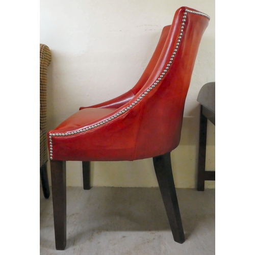 19 - A modern cherry red leather upholstered desk chair, raised on oak square, tapered legs