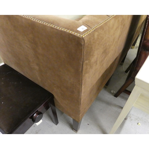 23 - A modern brown fabric button upholstered, box design three person settee, raised on mahogany block l... 