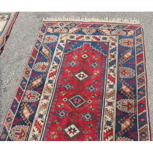 30 - A North Asian rug, decorated with geometric designs, on a multi-coloured ground  48