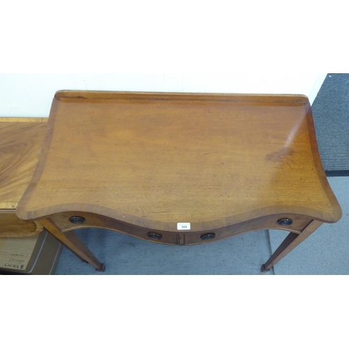 304 - A mid 20thC mahogany serpentine front cutlery table with two drawers, raised on square, tapered legs... 