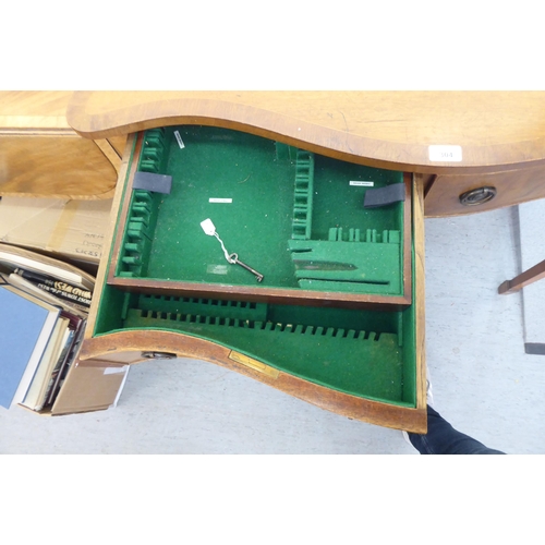 304 - A mid 20thC mahogany serpentine front cutlery table with two drawers, raised on square, tapered legs... 