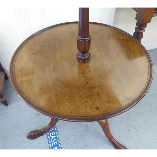 323 - A mid 19thC mahogany dumb waiter, raised on a turned column and tripod base  41