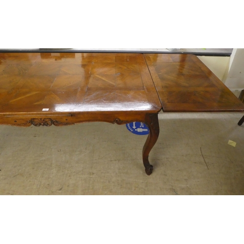 33 - A modern French oak dining table with a parquetry top, raised on cabriole legs  30