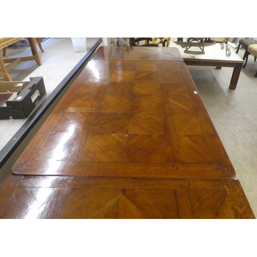 33 - A modern French oak dining table with a parquetry top, raised on cabriole legs  30