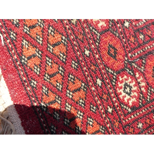 39 - Three rugs: to include a Turkoman, on a red ground  37