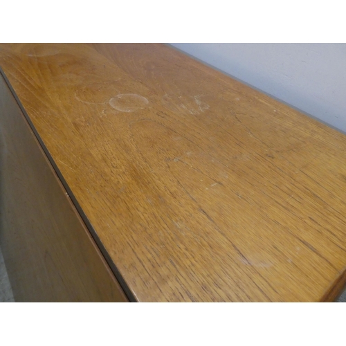 45 - A 1970s/80s teak drop leaf dining table, raised on platform ends  30