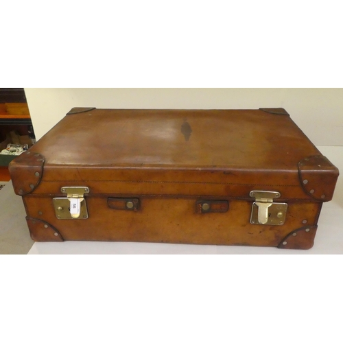 56 - A gentleman's stitched brown hide vanity case, the hinged lid enclosing a fitted interior with silve... 