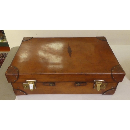 56 - A gentleman's stitched brown hide vanity case, the hinged lid enclosing a fitted interior with silve... 