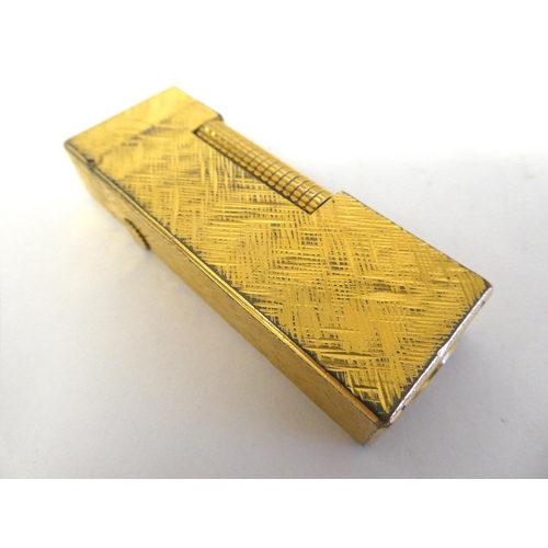 72 - A Dunhill textured and gilded steel cased, gas filled cigarette lighter; a Stratton powder compact; ... 