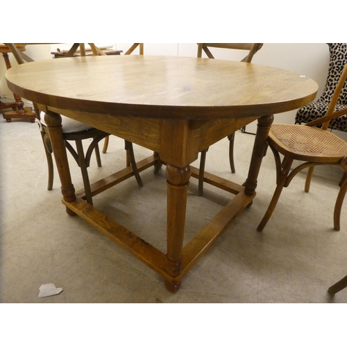 90 - A modern light oak dining table, raised on turned legs  30