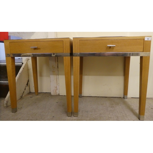 92 - A pair of modern light oak lamp tables, each with chrome trim and a drawer, raised on square legs&nb... 