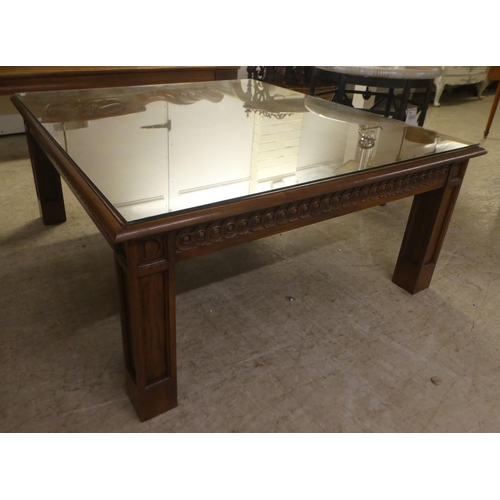 93 - A modern oak coffee/centre table with a carved frieze, raised on block legs  20